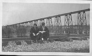 Two Men Sitting on Railroad Tracks